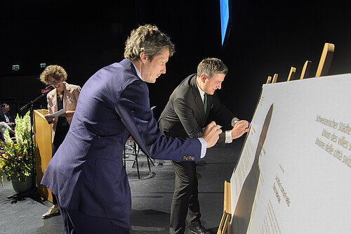 Il presidente dell’ACS Mathias Zopfi (a destra) e Martin Staub del Comune di Vernier firmano la dichiarazione dei comuni e delle città.