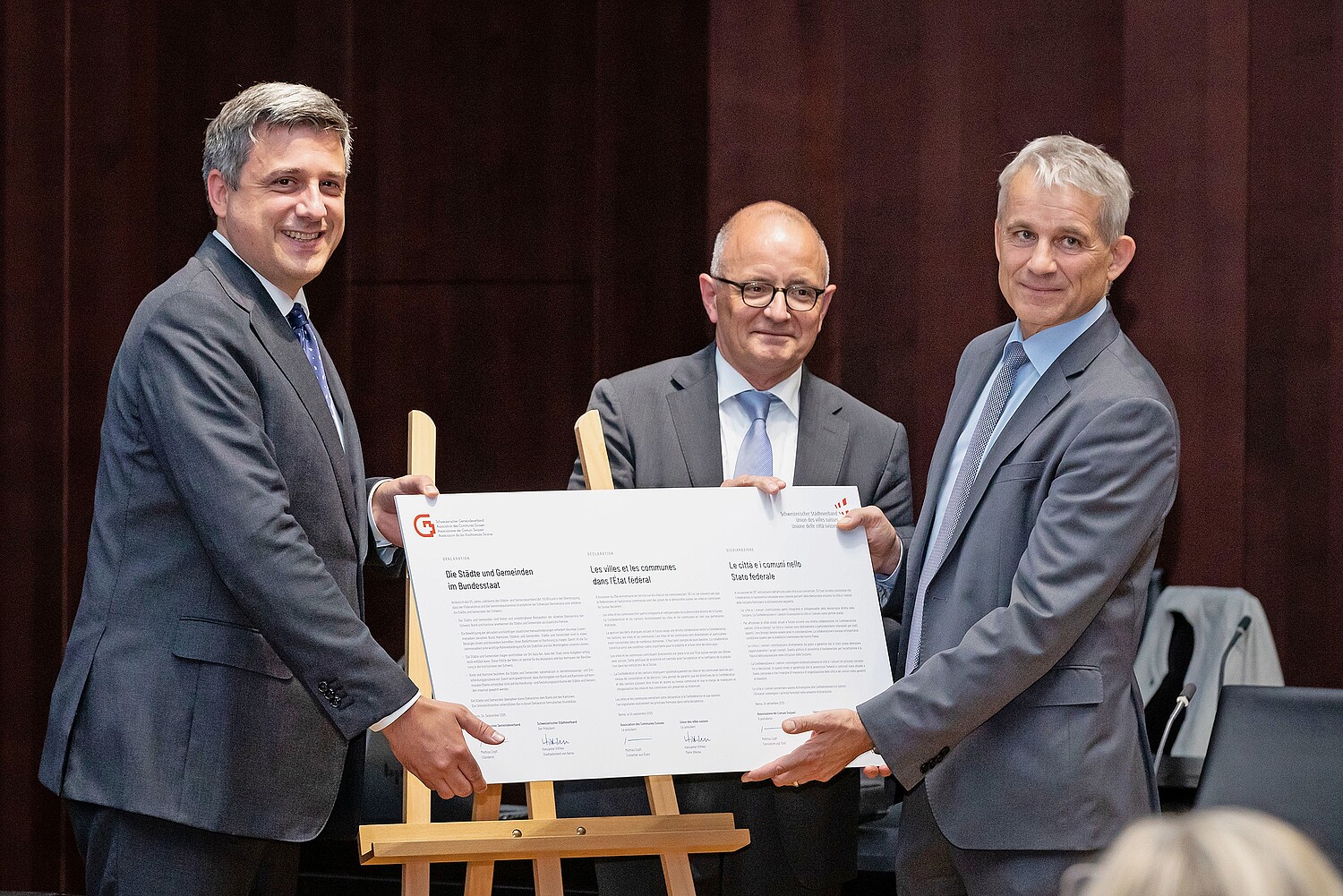 Consegna della dichiarazione al consigliere federale Beat Jans (a destra) da parte di Hanspeter Hilfiker (al centro), sindaco di Aarau, presidente dell'UCS, e del consigliere agli Stati Mathias Zopfi (a sinistra), presidente dell'ACS, nella sala della cupola del Palazzo federale.